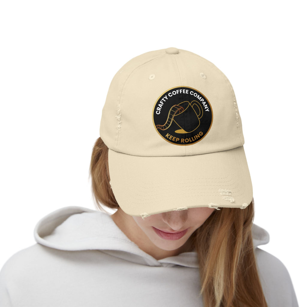 Beige cap with  the Crafty Coffee Company logo worn by a person on a white background