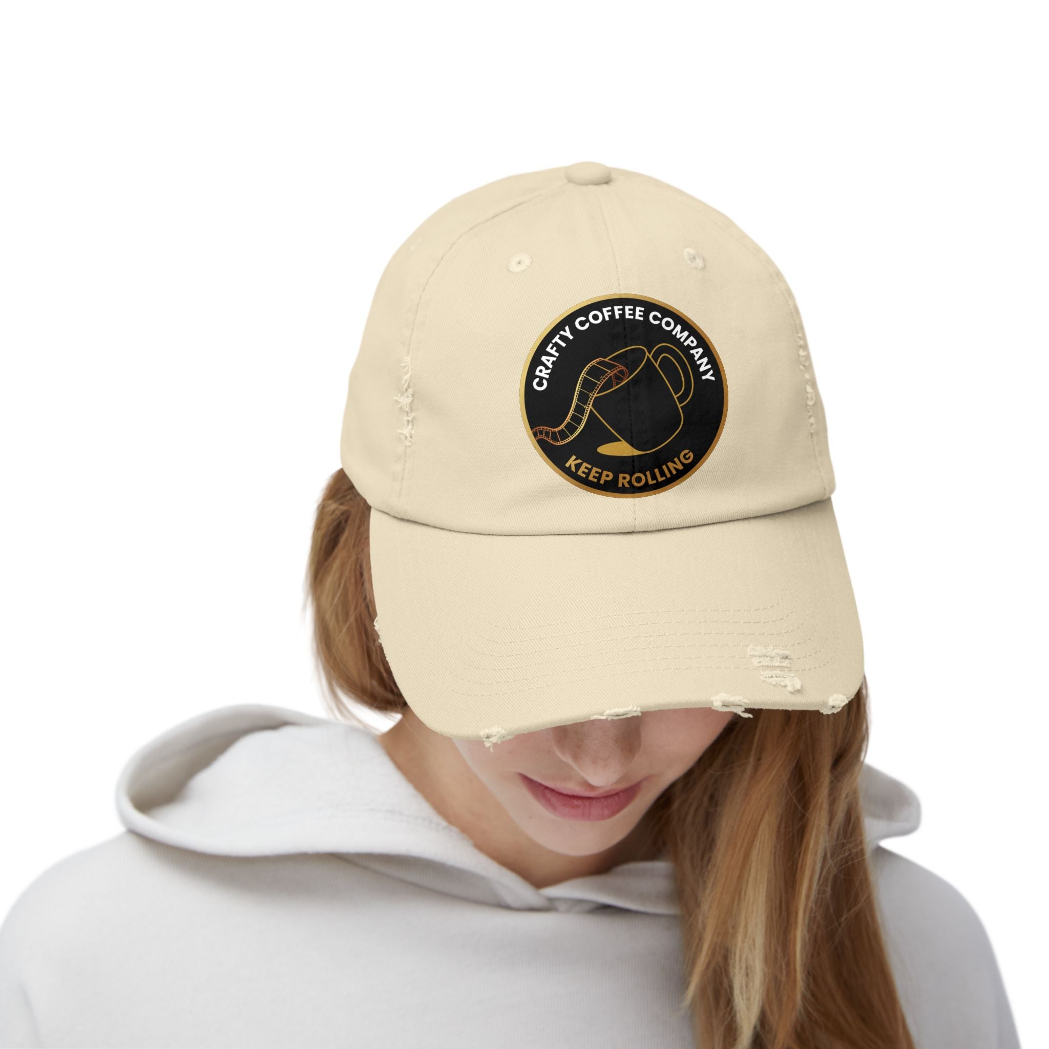 Beige cap with  the Crafty Coffee Company logo worn by a person on a white background